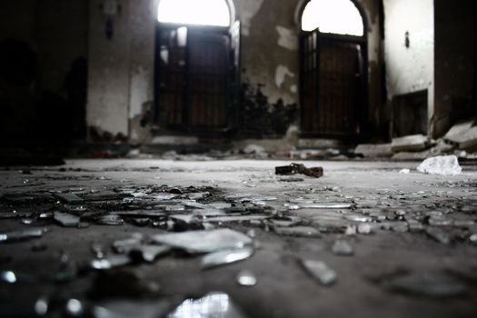 broken glass on the floor in the lobby of an abandoned apartment building