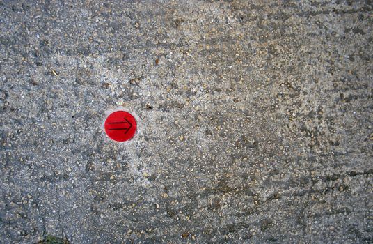 An arrow points the way on a sidewalk in Avignon, France.