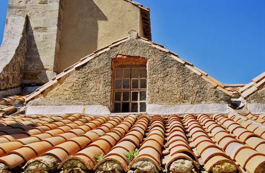A window above a terra cotta tiles roof in Gigondas, France.