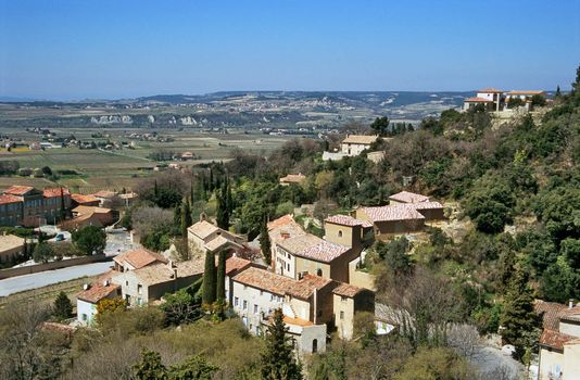 Rural villages hugging the hillsides are insterspersed with vineyards in the Provence region of France.