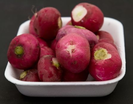 Some garden radishes on a black background