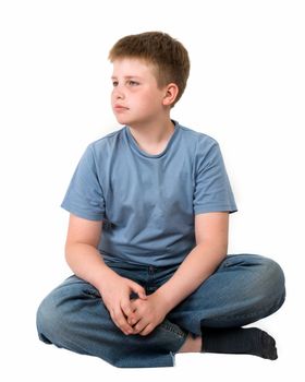 serious little boy sits on a white background