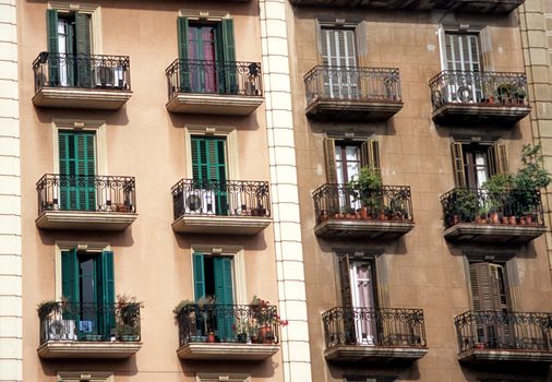 Wrought iron balconies are covered with flowers and greenery in Barcelona