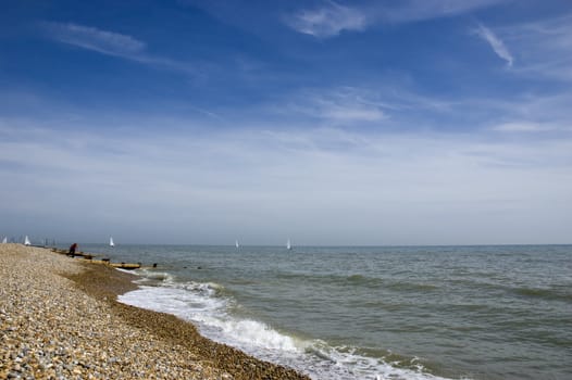 A view of a pebble beach with a blue sky