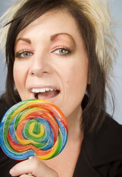 Portrait of a creative businesswoman with wild hair holding a lollipop