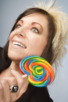 Portrait of a creative businesswoman with wild hair holding a lollipop