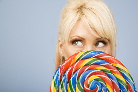 Woman holding a big colorful lollipop