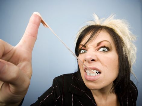 Portrait of a creative businesswoman stretching gum, on her fingertip