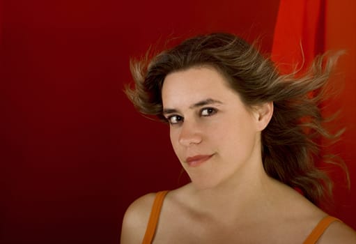 Young and beautiful woman portrait on a red background