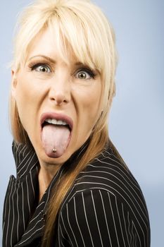 Woman in a pinstriped suit sticking out her pierced tongue