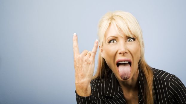 Businesswoman in a pinstripe suit making a bull horns sign