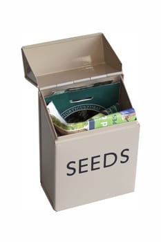 A tin seed box containing packets of seeds. Set on a white isolated background.