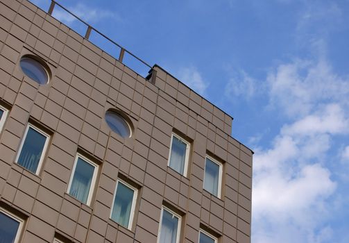 modern office building over blue sky with clouds