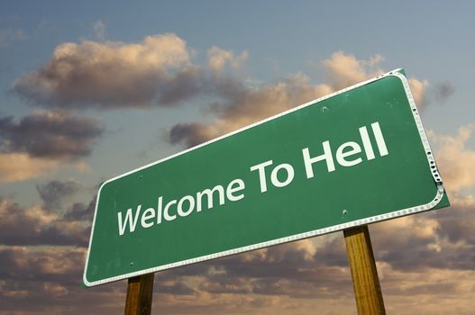 Welcome To Hell Green Road Sign with dramatic clouds and sky.