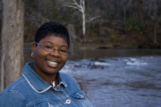 African American woman standing in front of a river