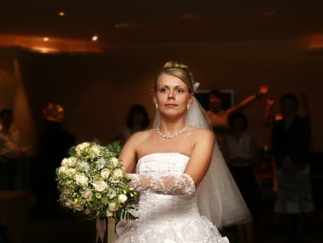 The bride throws a wedding bouquet to the girlfriends