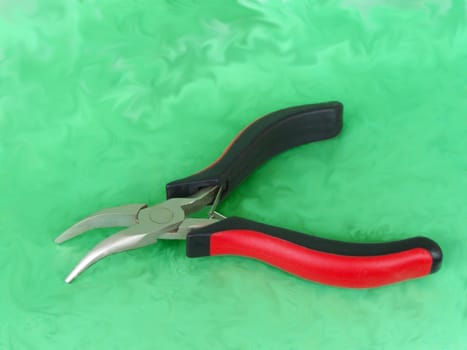 Red and black colored crimper with special shape. Macro.