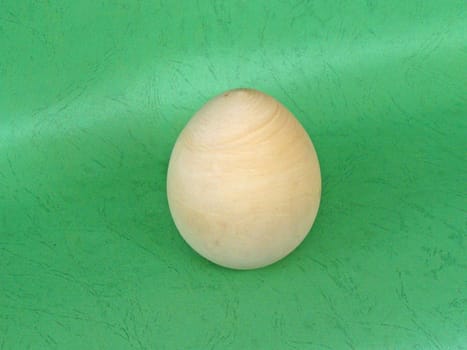 Wooden egg with green background. Close up.