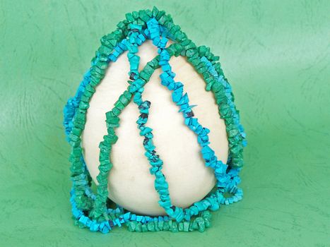 Wooden egg for easter and colorful turquoise and  malachite. Macro.