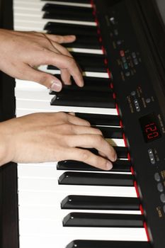 close up of a man's hands playing a piano keyboard