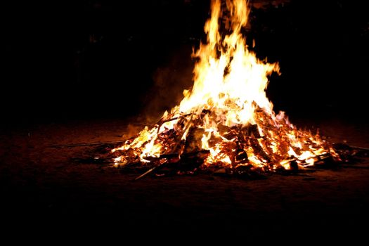 close up of bonfire and flames on a black background 