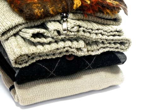 Folded woolen sweaters isolated in a white background

