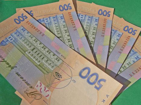 Five hundred grivnya banknotes at the green table. Macro