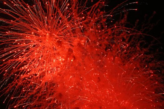 Abstract red fireworks explosion in the night sky.
