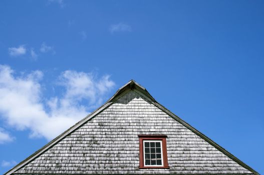 Roof of an old rustic house on blue sky background.