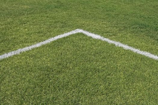 Corner boundary lines of a green grass playing field.