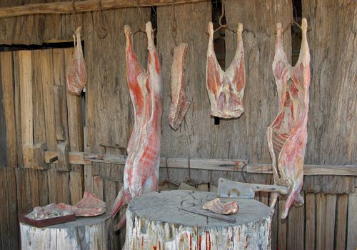 meat hangs in the heat in front of old heritage butchers shop
