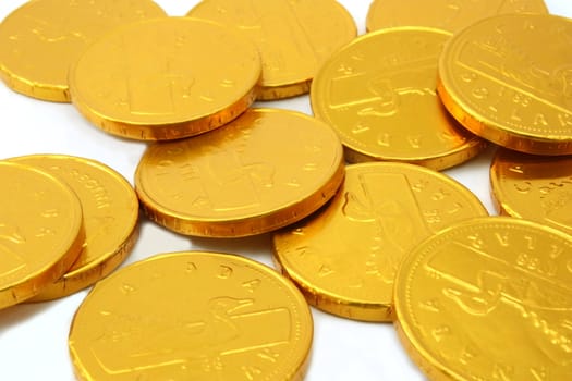 Scattered gold chocolate coins, white background