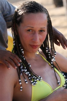 Woman sitting on the beach with new braids