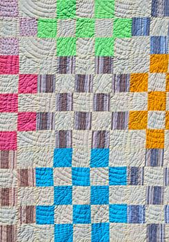 Bright patchwork counterpane made of pieces of cloth of different colors.