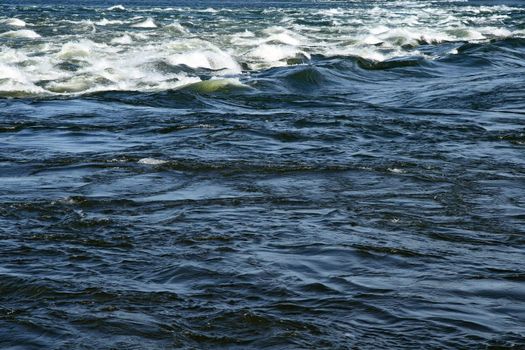 Water surface texture. Waves splashing in a river.