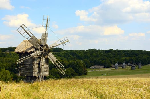 Old windmill in front of forest