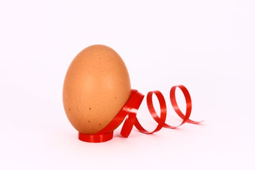 Chicken egg with decorations with red band