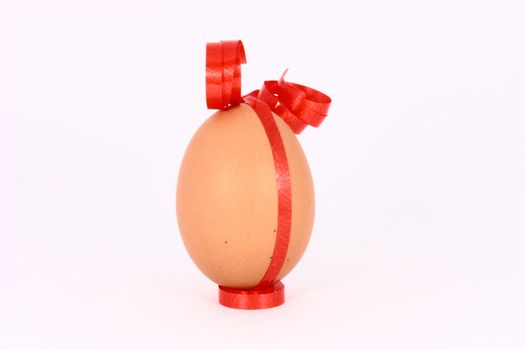 Chicken egg with decorations with red band