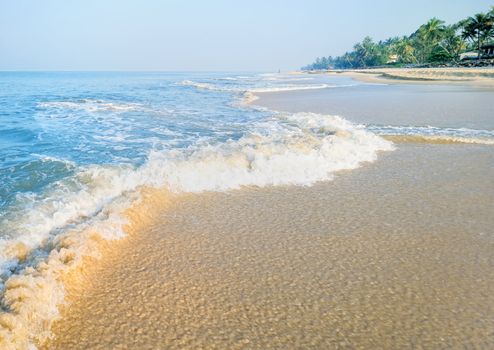 Slight waves on the sandy shore of the sea