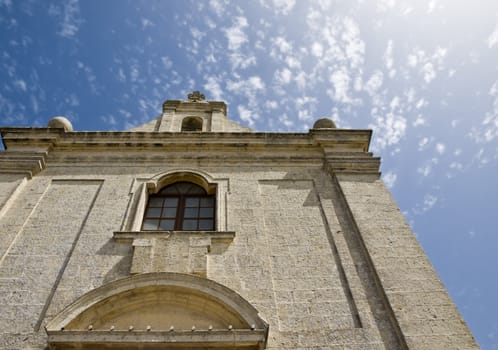 A medieval little chapel against blue sky and clouds