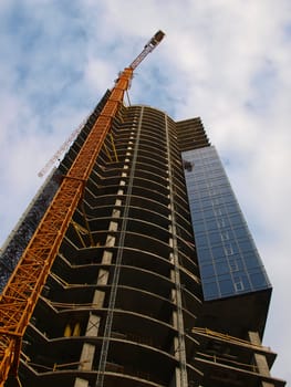 A crane and skyscraper building under construction