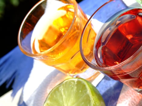 Close-up of two mini drinks and a half cut lime