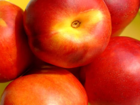 Some ripe peaches in a yellow basket