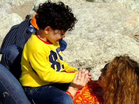 Mother and child playing on the rocks at the seaside