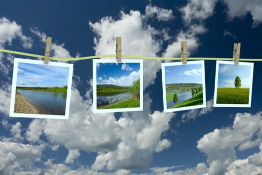 Landscape photographs hanging on a clothesline against a cloudscape