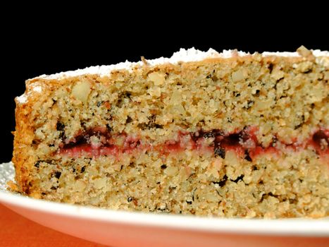 Homemade buckwheat cake with cranberry marmalade decorated with icing sugar