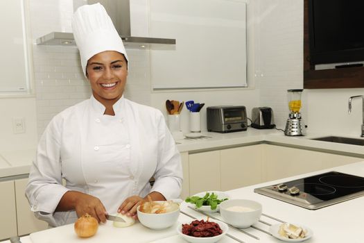 Happy chef cutting onions in a modern kitchen