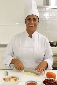 Happy chef cutting onions in a modern kitchen