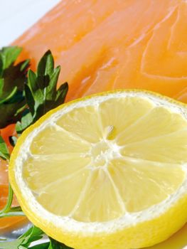 Close-up of a raw salmon fillet with lemon and parsley