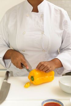 Professional chef cutting yellow pepper